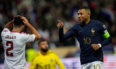 Kylian Mbappé celebrates scoring France's 11th goal while Gibraltar’s Ethan Jolley holds his head in his hands.