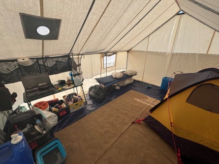 A neatly organized canvas tent with a nylon tent in the middle