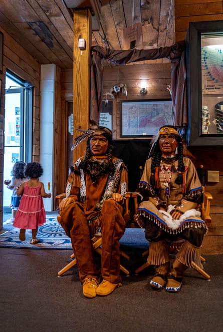 Two wooden caricatures of Indigenous people inside a shop