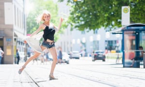 A confident young woman dancing on a city street