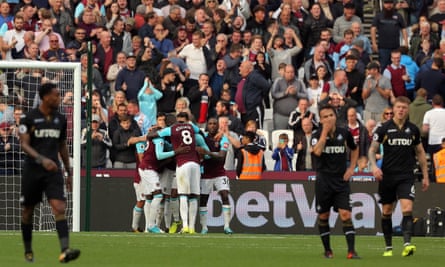 Diafra Sakho is mobbed by team-mates after scoring the only goal as Swansea players stand dejected.
