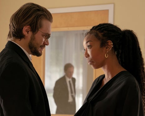 A woman dressed in black gazes doubtfully into the eyes of her husband