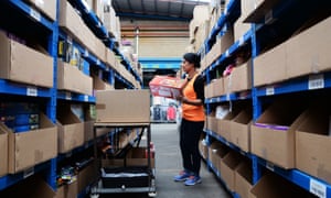 A worker removes stock in a warehouse