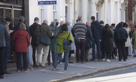 People queue outside a Covid-19 vaccination centre to receive a booster vaccination in London