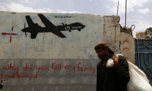 A Yemeni man walks past graffiti showing a US drone after al-Qaeda in Yemen confirmed the death of its leader in US drone strike, in Sana'a, Yemen, 16 June 2015