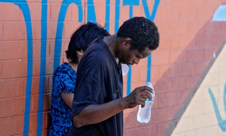 a man pours water on head and stands next to a women outside