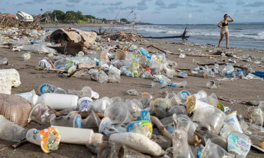 Plastic cups and other debris cover a beach in Bali, Indonesia