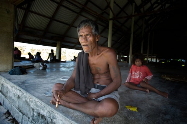 A village resident of Tebuginako, Abaiang island, looking out from the village ‘maneaba’ or meeting house. The structure now sits isolated at high tide because of sea inundation.