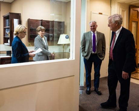three women and two men stand in a corridor three women and two men stand in a corridor