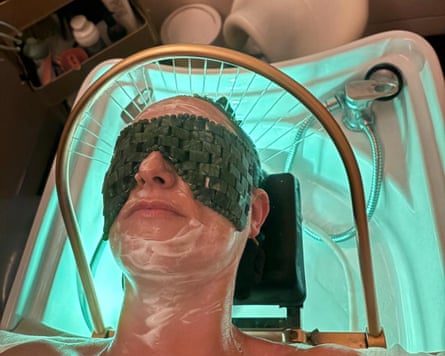 A woman reclines in a chair wearing an eye mask during a head spa treatment