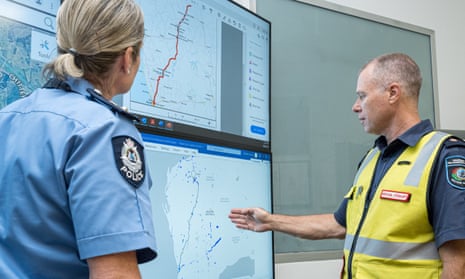 WA emergency coordinators organising a search for a missing radioactive capsule, man is gesturing at maps while a woman in police uniform looks on
