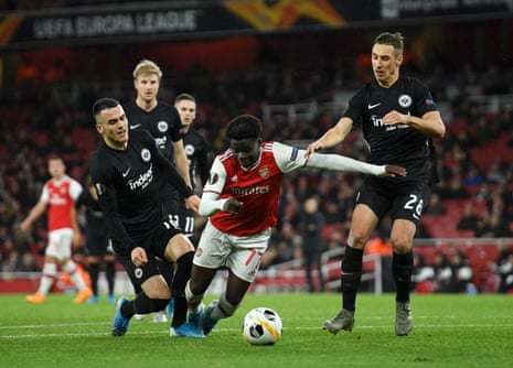 Bukayo Saka of Arsenal is tackled in the area by Filip Kostic and Dominik Kohr of Eintracht Frankfurt.