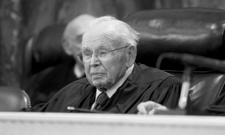 A black and white image of an elderly man wearing glasses and judge’s robes.