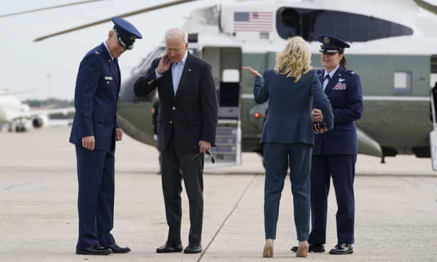 Biden brushes a cicada from his neck as he and the first lady, Jill Biden, prepare to board Air Force One at Joint Base Andrews in Maryland no Wednesday.