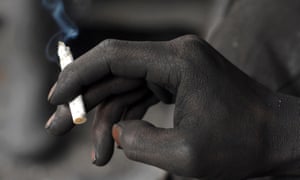 A miner smokes a cigarette during a break at the Gongxigou coal mine on the outskirts of Baokang, Hubei province, December 4, 2007. America taxes cigarettes, but subsidizes fossil fuels.