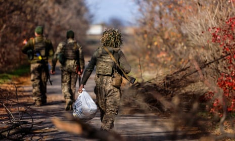Ukrainian soldiers move along a street in the northern Kherson region as Russia withdraws its troops from Ukraine’s southern city.