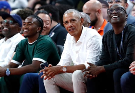 Former US president Barack Obama, center, watches Wednesday’s exhibition between the United States and Canada.