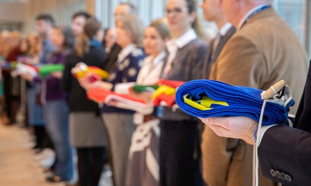 European Medicines Agency staff hold the folded flags of the 28 EU states