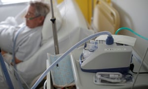 man with ventilator lying on a bed