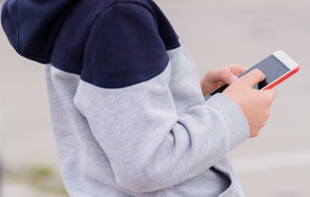 A child plays games on a smartphone outside