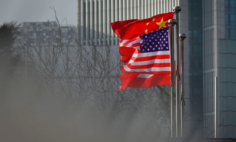 Chinese and US national flags flutter at the entrance of an office building in Beijing.