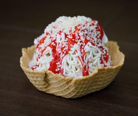 Spaghettieis ice-cream sundae with strawberry sauce in waffle cone cup