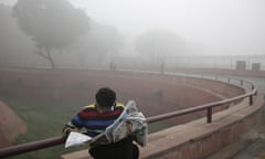 A man reads his newspaper in smog near Delhi’s Red Fort.