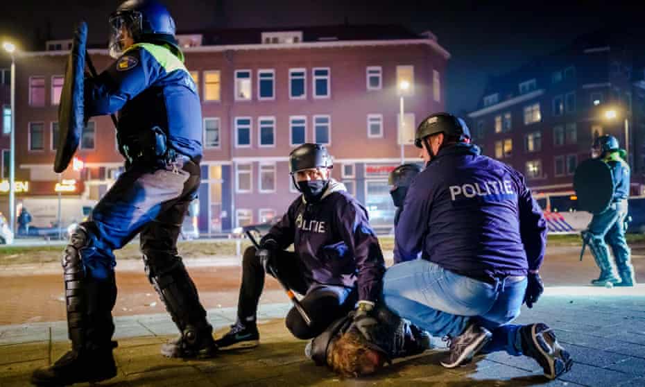 Dutch police officers arrest a man amid anti-curfew protests in Beijerlandselaan, Rotterdam, last month.