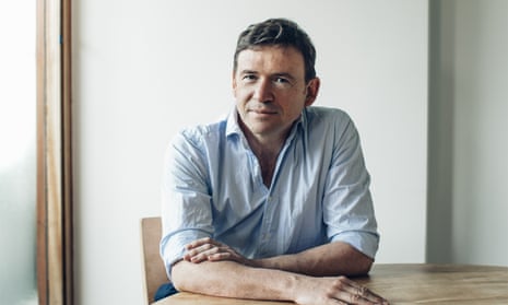 The author David Nicholls, sitting at a table.