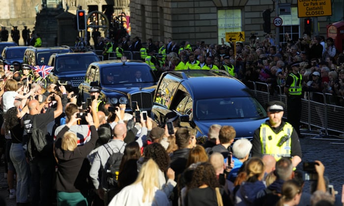 People watch as the Queen’s cortege with the hearse carrying Queen Elizabeth’s coffin departs from St Giles’ Cathedral en route to Edinburgh airport.