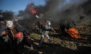 Palestinian protesters throw stones during clashes with the Israeli army on the border.