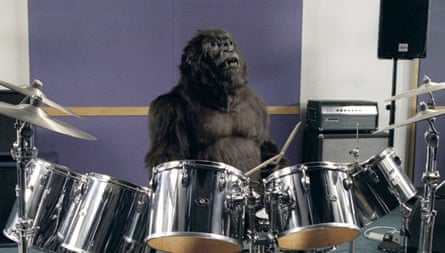 A gorilla plays the drums on a purple background