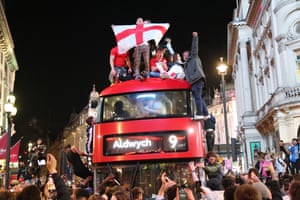 Jubilant fans climb on top of a bus in London