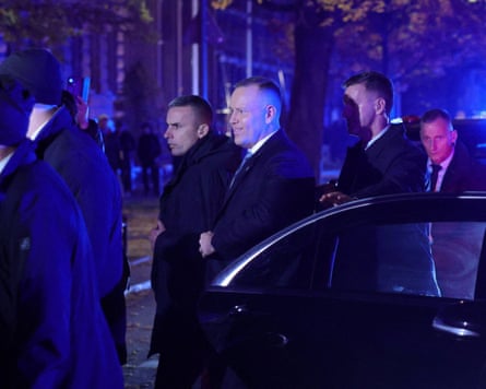 Polish President Karol Nawrocki, surrounded by security at night, walks out from his car
