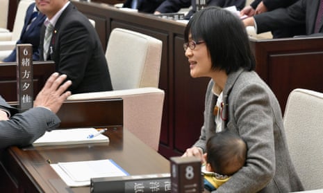 Yuka Ogata holds her baby during a session at Kumamoto municipal assembly.