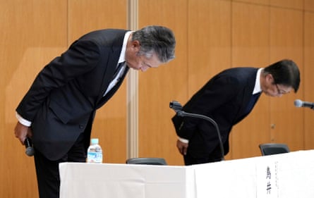 Suntory president Nobuhiro Torii and vice-president Kenji Yamada bow during a press conference announcing the resignation of Niinami