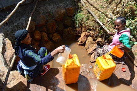 Women collect water from a muddy well in Sululta town in Ethiopia
