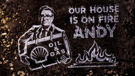 A land artwork shows Andy Burnham holding a oil drum and and words ‘Our house is on fire Andy’