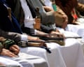 Houthis sit in a row, some holding automatic rifles