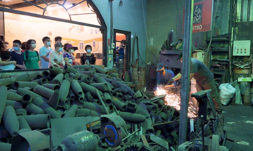 Trabajadores metalúrgicos que usan viejos proyectiles de artillería mientras observan