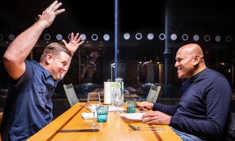 David holding his hands in the air in the middle of a conversation at a table with Vanchy