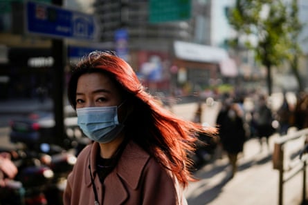 A woman wearing a face mask walks on a street in Shanghai on 13 December 2022, as Covid outbreaks continue.