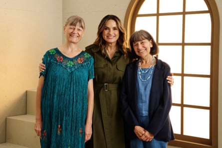 three women standing and smiling together