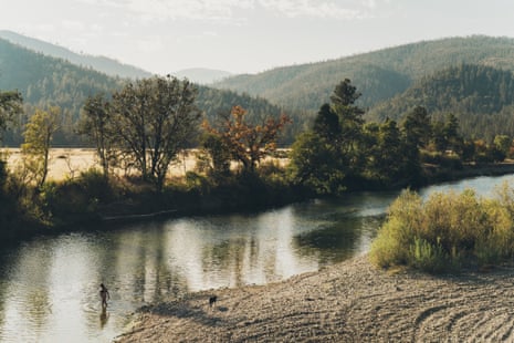 A creek surrounded by trees and mountains