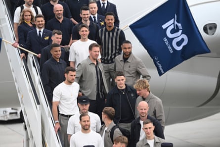 Players, team staff and cabin crew pose on airplane steps