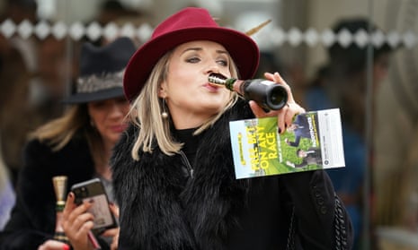 A racegoer drinking champagne on day three of the Cheltenham Festival.