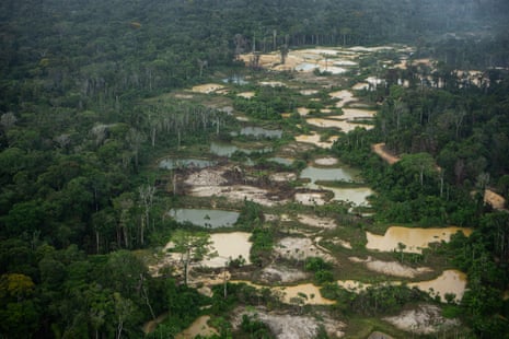 A trail of flooded mining pits cut through deep forest.