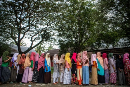 Rohingya refugees queue for aid at their temporary shelter in Pidie, northern Sumatra, Indonesia.