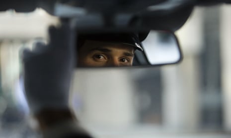A chauffeur looks in his mirror