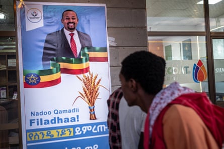 A man walks past an election poster showing a smiling man in a suit